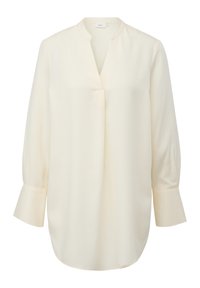 Blouse crème clair avec un col en V, des manches longues bouffantes et un ourlet courbe. Confectionnée dans un tissu lisse avec des coutures minimales et sans éléments métalliques visibles.