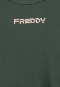 T-shirt in cotone verde scuro con logo "FREDDY" metallizzato rosa chiaro. Design classico con collo rotondo e maniche corte. Texture morbida.