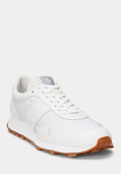 White low-top sneaker with lace-up closure, textured rubber sole, and subtle Polo logo on the side and tongue tab.