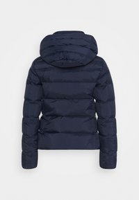 Veste matelassée bleu marine avec capuche, manches longues et couture horizontale, vue de dos sur un fond blanc.