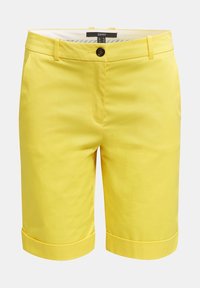 Pantalones cortos de algodón amarillos con corte recto, cierre frontal con botones y puños enrollados. Textura suave con costuras mínimas visibles.