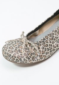 Baleriny w print leopardzi, z detalem w postaci kokardki, wykonane z teksturowanej tkaniny. Posiadają okrągły czubek i elastyczną podeszwę, w kolorach przeważnie beżowym i czarnym.