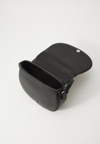 Borsa a spalla in pelle nera con pattina aperta, dotata di chiusura a scatto in argento, texture liscia e un ampio interno.