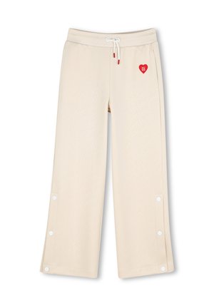 Pantalon beige à jambes larges avec taille à cordon, pressions latérales le long des jambes et petit logo cœur rouge près de la poche.