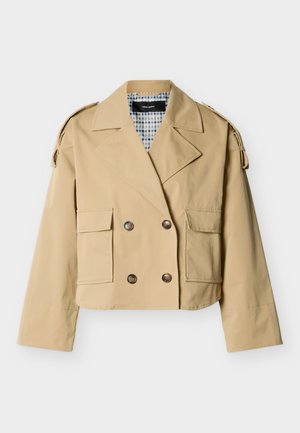 Jachetă bej scurtă cu dublu rând de nasturi, revere largi, buzunare cu clapetă, bretele pentru umeri cu nasturi și căptușeală a gulerului în carouri.