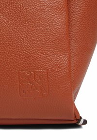 Borsa in pelle color arancione bruciato, superficie texturizzata, forma triangolare, dettaglio logo impresso e cuciture in contrasto.