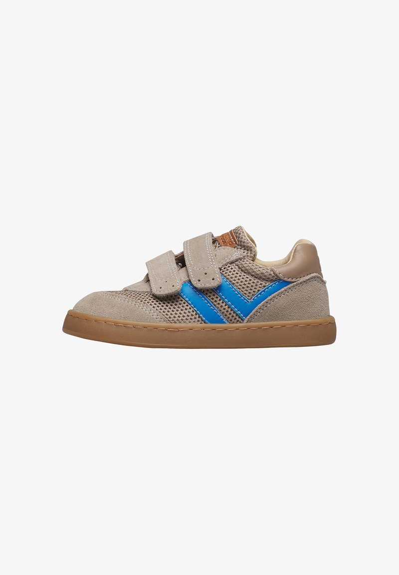 Zapatilla infantil beige con rayas laterales azules, parte superior de malla y ante, dos tiras de Velcro y suela de goma marrón.
