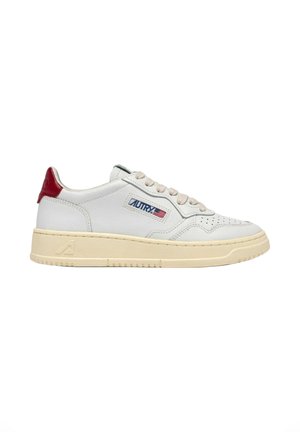 Sneaker bianco basso con suola beige, lacci beige, linguetta rossa sul tallone e logo "AUTRY" con bandiera americana sul lato.