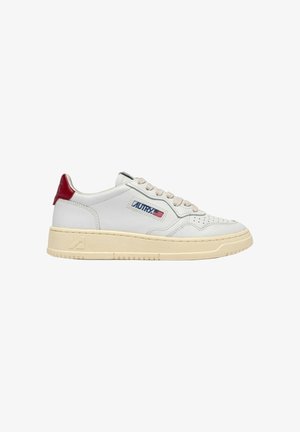 Sneaker bianco basso con suola beige, lacci beige, linguetta rossa sul tallone e logo "AUTRY" con bandiera americana sul lato.