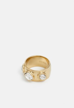 Gold ring featuring three clear, geometric crystals embedded on a smooth, polished band. Inside, "GUESS" is engraved.