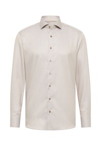 Camicia a maniche lunghe colore beige chiaro con un motivo testurizzato, colletto a punta e bottoni marroni lungo la pattina. Finitura del tessuto liscia.