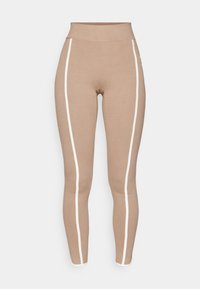 Leggings i ljusbeige tyg med hög midja, med vita sidostrek och en smidig, elastisk textur.