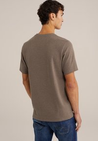 Tricou cu mânecă scurtă, de culoare maro deschis, fabricat dintr-un material texturat, având guler rotund. Purtați-l cu blugi albaștri, evidențiind o croială relaxată.