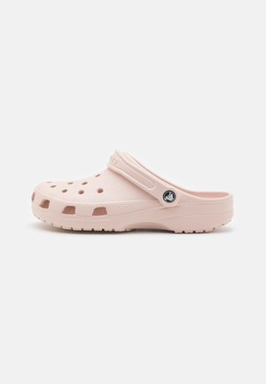 Light pink rubber clog with ventilation holes, a strap for back support, and textured outsole for grip. Smooth finish.