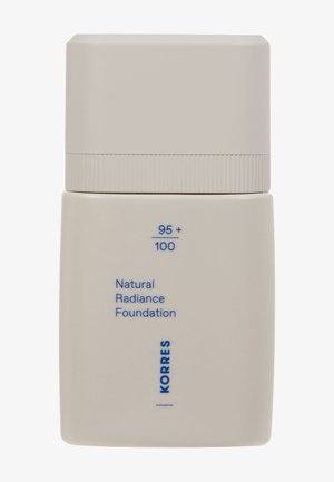 Bouteille de fond de teint rectangulaire beige avec une finition mate. Elle présente un bouchon texturé de couleur claire et des textes bleus imprimés pour le branding et les détails du produit.