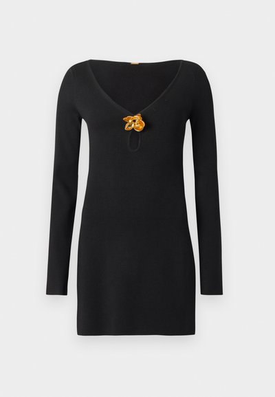 Black long-sleeve dress featuring a V-neckline and a keyhole detail, accented with a yellow floral brooch at the center.