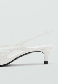 Valkoiset slingback-korkokenkä-sandaalit, joissa on sileä pinta, hoikat hihnat, hieman terävä kierroste ja 5 cm musta korostuskorko.
