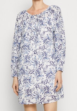 Robe à imprimé floral avec des manches longues, un col élastique et des détails en bouton. Le tissu présente des fleurs bleues et violettes sur un fond clair.