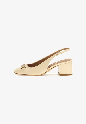 Pompe à talon slingback en cuir verni beige avec un bout arrondi, un talon bloc et un accent en boucle en métal sur le dessus. Texture lisse, design élégant.