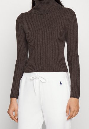 Brun ribbet turtleneck sweater med lange ærmer, tætsiddende design og blød tekstur, parret med hvide sweatpants med et logo.
