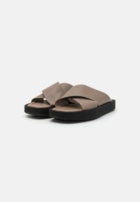 Brown leather slip-on sandals with wide cross straps, a black platform sole, and smooth texture. No distinct patterns or hardware visible.