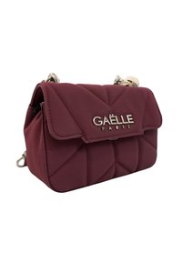 Borsa a mano in ecopelle borgogna con design trapuntato, hardware argentato e chiusura a pattina. Dotata di una tracolla a catena corta.