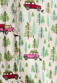 White fabric featuring a pattern of pink and red retro vehicles among green trees, with a black-and-white dog. Five buttons on the front.