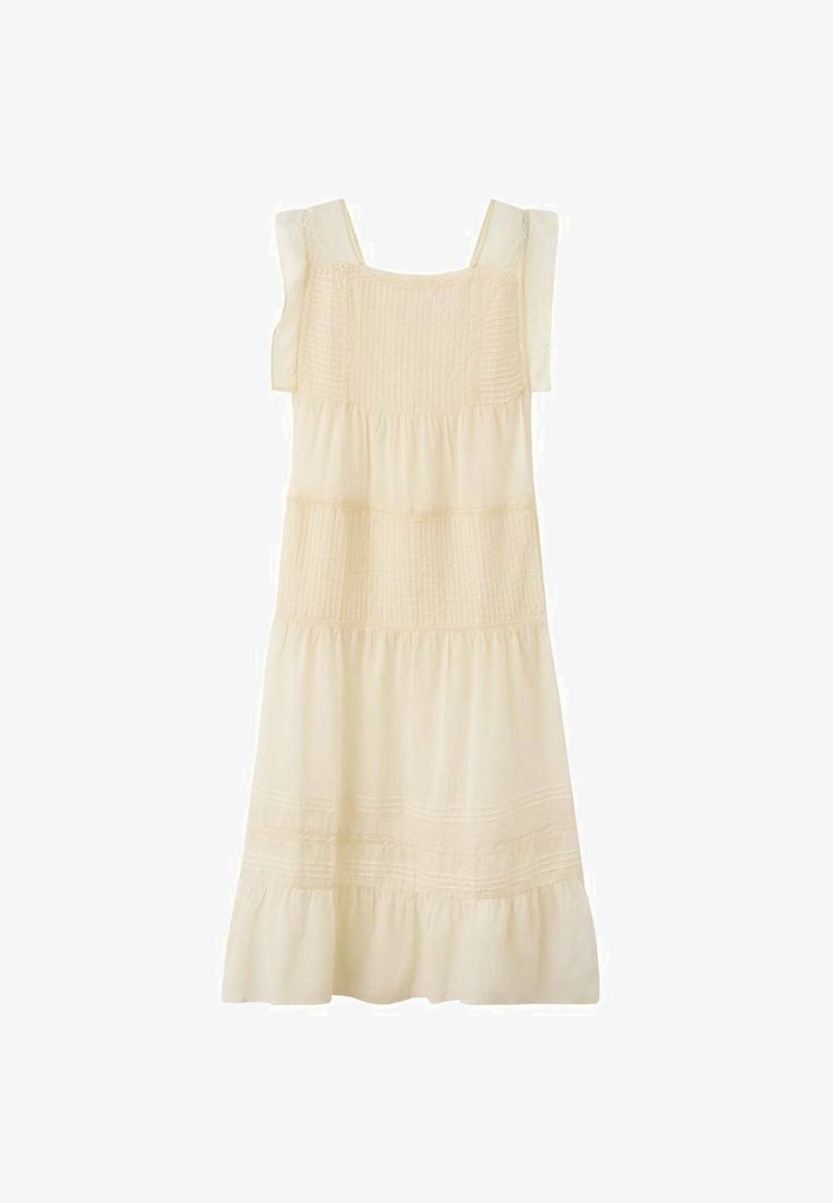 Rochie de culoare crem, cu un corset elastic, bretele late și o fustă în straturi. Prezintă un material moale și detalii de cusătură orizontală subtile.