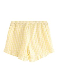 Gule ternede shorts med elastisk talje og flæset kant. Fremstillet af et letvægtsstof med et kvadratisk ternet design.