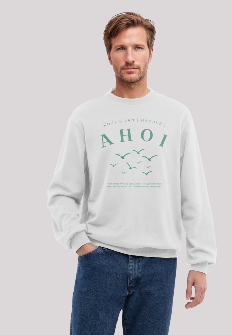 Weiße Sweatshirt mit grünem Text "AHOI" und Vogelgrafiken. Ausgestattet mit "Knut & Jan Hamburg" darüber und einem beschreibenden Text darunter.