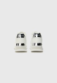 Hvide sneakers med en metalhælsaccent og "REPLAY" branding. Har en glat overdel, polstret sål og et strømlinet design.