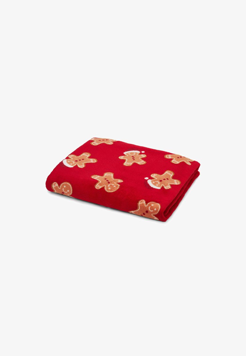 Coperta in pile rossa con un motivo ripetuto di omino di pan di zenzero in beige con accenti rossi. Tessuto morbido con design piegato.