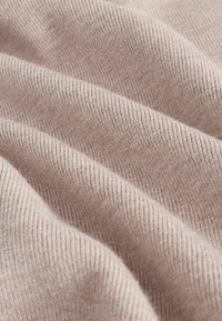 Tejido acanalado de color rosa claro con una textura sutil, que muestra suaves pliegues y una superficie lisa. Líneas horizontales notables debido a la acanaladura.