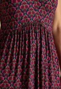 Blumendruckkleid mit dunklem Navy-Hintergrund, rosa und grünen Blumen, plissierter Gestaltung und weichem Stoff.