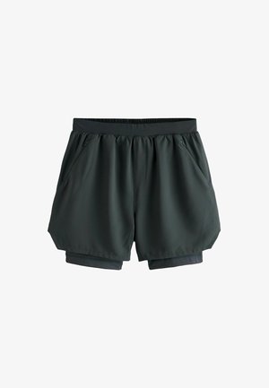 Dunkelgrüne Sportshorts aus glattem, leichtem Stoff. Verfügen über einen gerafften Bund und zwei Seitentaschen. Die innere Schicht ist kürzer.