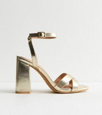 Gold metallic high-heeled sandal with ankle strap. Features two crossed front straps and a chunky, square heel. Smooth texture throughout.