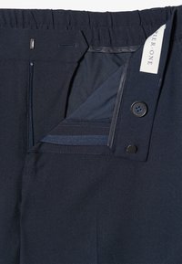 Μπλε παντελόνια ναυτικού χρώματος με επίπεδη μέση, κλείσιμο με κουμπί και φερμουάρ. Διαθέτουν απαλό ύφασμα και αντίθετες υφασμάτινες λεπτομέρειες στο εσωτερικό της τσέπης.