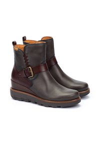 Botas de tobillo de cuero gris oscuro con una correa de hebilla marrón y detalle trenzado. Interior acolchado y entresuelo texturizado. Diseño de punta redonda.