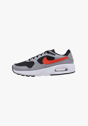 Nike sneakers met een bovenwerk in zwart en grijs, een oranje swoosh, een witte tussenzool en een zwarte rubberen buitenzool. Lichtgewicht ontwerp met mesh accenten.