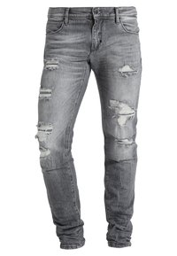 Jeans grises desgastados con detalles rasgados, diseño de cinco bolsillos y un ajuste slim. Fabricados con tela de mezclilla con un efecto de lavado desvanecido.