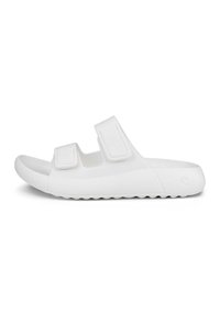 Hvite slip-on sandaler laget av glatt, fleksibelt materiale, med to justerbare borrelåsremmer og en teksturert såle for godt grep.