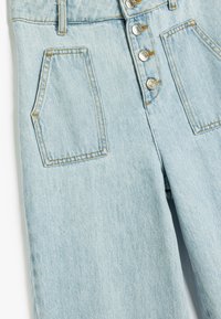 Pantalones de mezclilla azul claro con cintura alta, cierre de cinco botones y dos bolsillos frontales con costuras visibles.