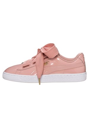Błyszczące jasno-różowe buty sportowe Puma z grubymi teksturowanymi sznurowadłami związanymi na kokardę i białą gumową podeszwą.