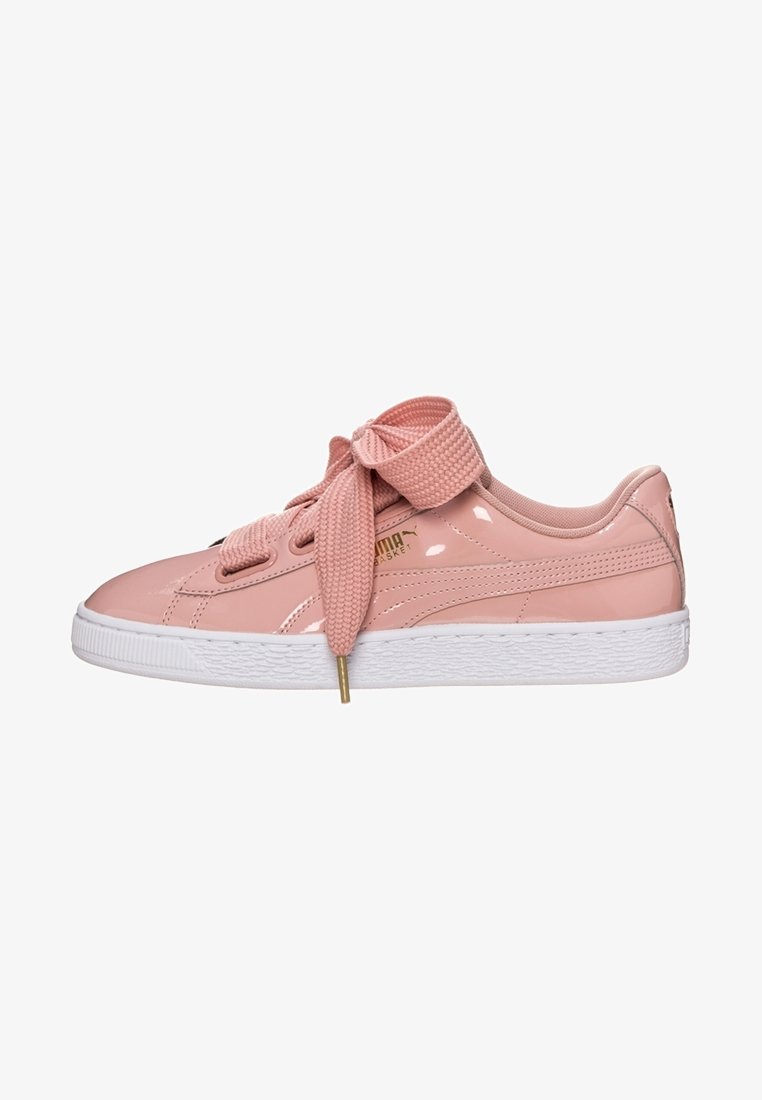 Baskets Puma rose clair brillantes avec des lacets épais texturés noués en nœud et une semelle en caoutchouc blanche.