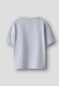 Camiseta de algodón azul claro de mangas cortas, con un corte relajado, cuello redondo y textura lisa. Sin patrones ni gráficos visibles.