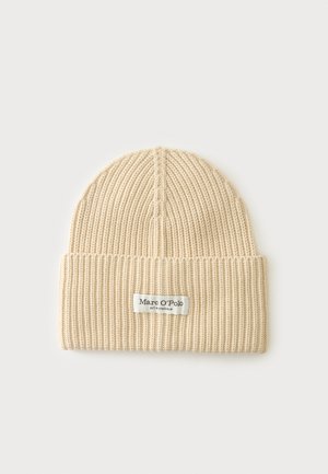 Bonnet beige en maille côtelée avec bord replié et étiquette en tissu blanche affichant la marque Marc O'Polo.