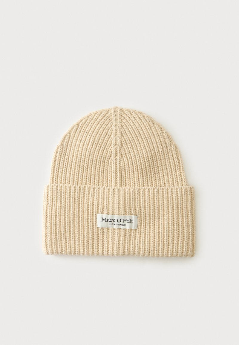 Bonnet beige en maille côtelée avec bord replié et étiquette en tissu blanche affichant la marque Marc O'Polo.