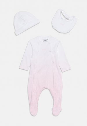Ensemble de vêtements pour bébé blanc comprenant un body à manches longues avec pieds, un bonnet et un bavoir, tous unis avec peu de détails.