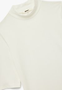 Camiseta blanca de cuello mao hecha de tejido suave, con mangas cortas y una textura lisa y sin imperfecciones, con un diseño minimalista.