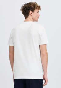 Hvit bomulls t-skjorte med korte ermer, rund hals, og et enkelt design. Glatt tekstur, avslappet passform, og minimale sømdetaljer.